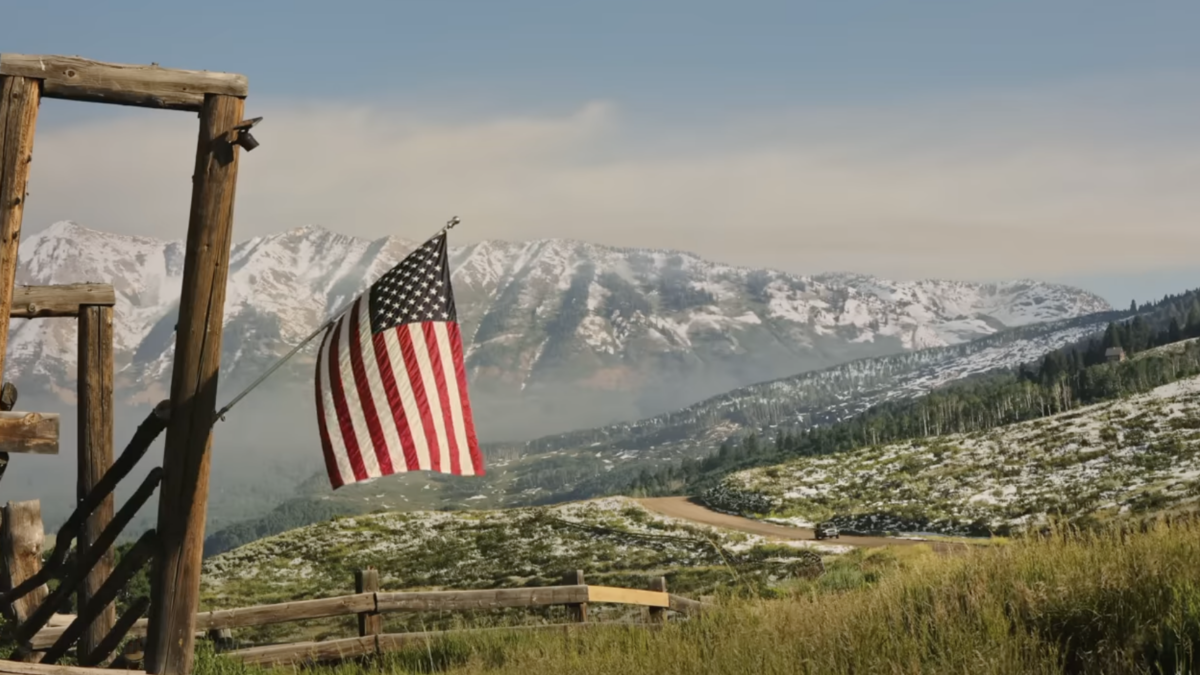 American flag with mountains in the distance